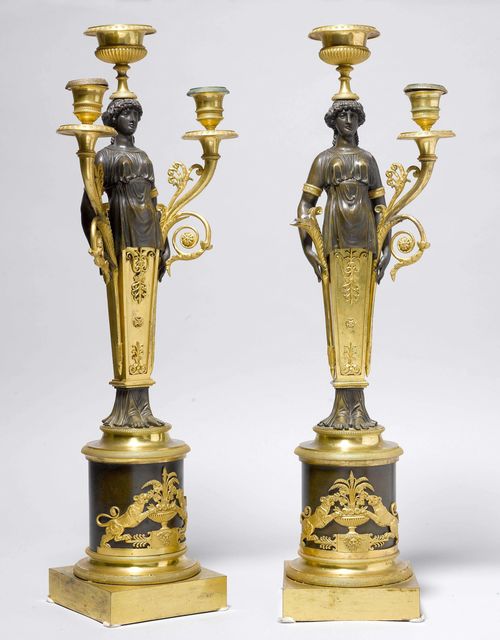 PAIR OF CANDELABRAS,France, in the style of J.F. DENIERE (Jean-François Denière 1774-1886). Matte and polished gilt bronze, and burnished bronze. Young woman holding a vase, with central nozzle and 2 curved light branches with mascarons and round drip pans. Fine matte and polished gilt bronze mounts and applications designed as dogs, floral decorations. H 57 cm. 1 arm, broken.