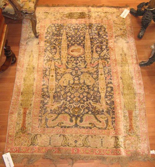 KAYSERI SILK antique.Dark central field decorated with plants and animals in delicate pastel colours, beige border with two trees, slight signs of wear, 170x120 cm.