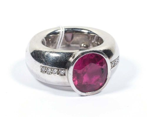 RUBELLITE AND BRILLIANT-CUT DIAMOND RING. White gold 750. Modern, slightly convex band ring, the top set with 1 round pink coloured tourmaline of 6.02 ct, flanked by 8 brilliant-cut diamonds totalling 0.12 ct. Size ca. 51, with size-adjustment insert. With copy of invoice, 2006.