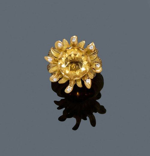 CITRINE, BRILLIANT-CUT DIAMOND AND GOLD RING. Yellow gold 750, 74g. Modern, broad and textured ring in the shape of a stylised flower, set with 1 round citrine of ca. 13.26 ct, the petals and the back additionally decorated with 9 brilliant-cut diamonds totalling ca. 0.50 ct.