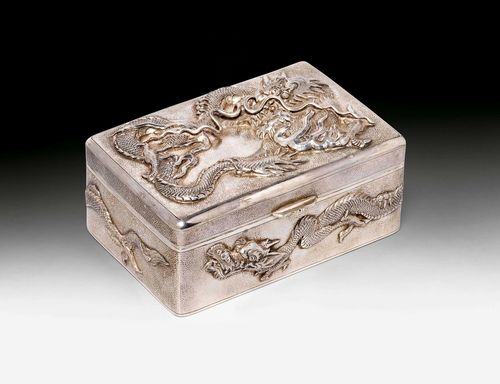 A SILVER BOX AND COVER WITH DRAGON MOTIF. China, early 20th c. 5.5x13x8.5 cm. On the base the marks: "Zeesung", "90" and two characters. Inner box of wood. Dedication in German: "Christmas 1927, Shanghai".