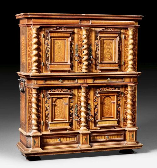 MINIATURE DOUBLE CABINET,Renaissance style, German, 19th century Various fruitwoods in veneer and finely inlaid with stylised flowers and leaves. With overhanging cornice, shaped plinth and bun feet; double doors between turned pilasters under 2 drawers on the lower section and with a recessed upper section with corresponding doors. Iron mounts and lock, with carrying handle. 50x16x53 cm. Provenance: from a French private collection.