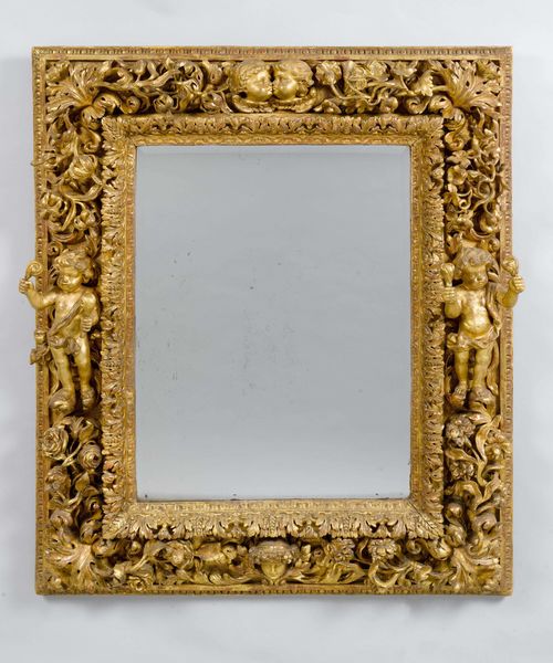 IMPORTANT MIRROR,Baroque style, Italy, 19th century. Wood, opulently carved with flowers, leaves, acanthus, putti and angel heads, and gilt. Rectangular frame. H 145, W 119 cm. Repairs and some losses.