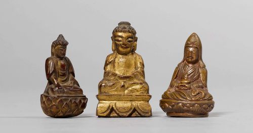 THREE SMALL SEATED BUDDHAS OF BRONZE, GILT WOOD, AND GOLD LACQUER. Tibet and China, heights 4.5-5.5 cm. (3)