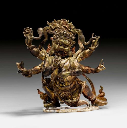 A BRASS FIGURE OF A MAHAKALA. Tibeto-Chinese, 18th/19th c., height 11 cm. Slight traces of gilding. Elephant hide lost from the back. Minor restoration. Glued to a small agate plate.
