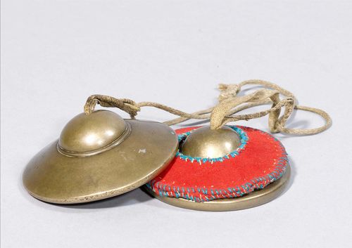 A PAIR OF METAL ALLOY CYMBALS (tib. tingshag). Tibet, antique, diameter 8.5 cm. Leather band and cloth cover.