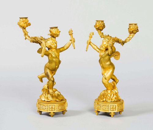 PAIR OF CANDELABRAS WITH PUTTI,France, Louis XV style. Bronze, gilt. Putto with extended arms, holding a torch in the left hand, the right hand holding a candlestick with 2 light branches. Rose-shaped nozzles. On a round foot with pierced leaf decoration. H 35 cm.