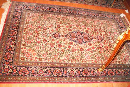 GHOM old.White ground with a black central medallion, finely patterned with trailing flowers in shades of pink, black border, good condition, 210x140 cm.
