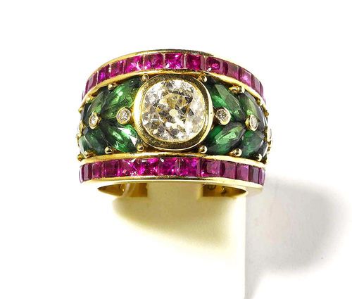 DIAMOND, RUBY, TSAVORITE AND BRILLIANT-CUT DIAMOND RING, PÉCLARD. Yellow gold 750. Broad, elegant band ring, the top set with 1 old-mine-cut diamond of 1.85 ct, flanked by 16 navette-cut tsavorites totalling 3.32 ct and additionally adorned with 10 brilliant-cut diamonds totalling 0.11 ct. The rim set with 30 Princess-cut rubies totalling 2.74 ct. Size ca. 51. With copy of invoice.