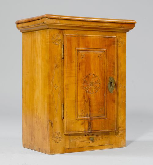 HANGING CUPBOARD,late Baroque, from the Alpine region, 19th century. Walnut, carved with rosettes and rhombi. Rectangular body with a door over a drawer. 38x24x47 cm.