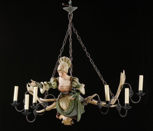 ANTLER CHANDELIER,in the Renaissance style, 19th century. Painted papier mâché and antlers. Designed as a female bust with a coat-of-arms cartouche. 6 curved light branches. Fitted for electricity. 102x80x50 cm. Some losses.