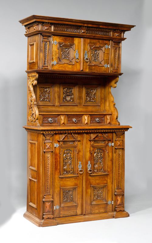 BUFFET WITH COMPARTMENTS, in the Renaissance style, probably Switzerland or Germany. Walnut, opulently carved with decorative friezes, leaves, rosettes and coats-of-arms. Architecturally designed front, the top with double-doors, the centre part with 3 drawers, and the lower part with double-doors. Iron mounts. 118x53x223 cm.