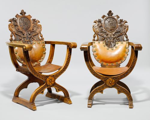 PAIR OF SCISSOR CHAIRS,in the Renaissance style. Walnut, carved with a coat-of-arms, mascaron, decorative frieze and mythical creatures. Rectangular, leather seat with a curved X-shaped frame. Curved, partly padded backrest. 67x74x112 cm.
