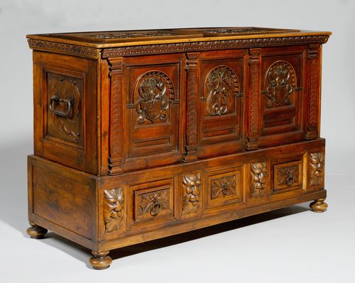 CHEST,Historicism, Switzerland, 19th century. Walnut, carved with lion heads, mascarons, coats-of-arms and leaves, and inlaid with fillets. Dated 1682. Rectangular body with hinged cover. Iron handle and lock. 143x56x93 cm. 1 key.