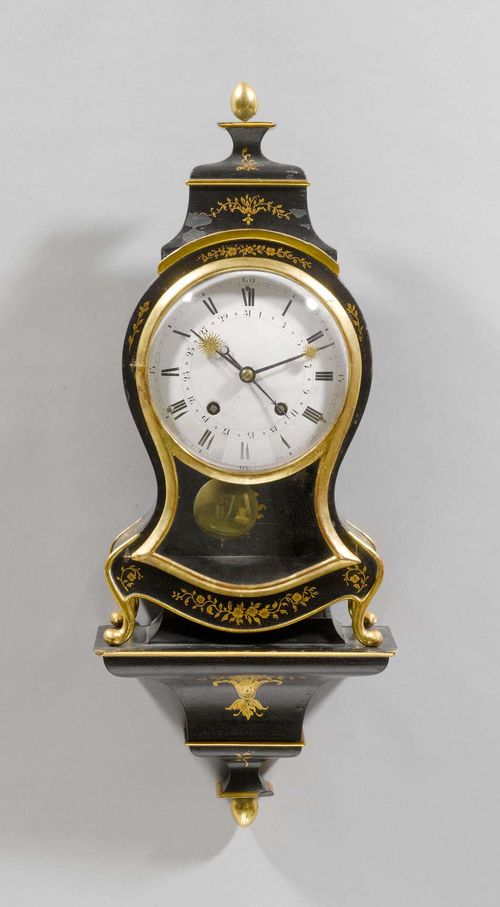 SMALL CLOCK ON PLINTH WITH DATE, Neuchâtel, 1st half of the 19th century. Case painted with golden flowers and garlands on black ground. White enamel dial (chipped). Movement with verge escapement striking the 3/4-hour on 2 gongs. H 67 cm. Movement requires servicing.