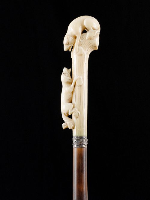 WALKING STICK WITH WALRUS TUSK HANDLE.Grip featuring 2 hyenas. Bamboo stick with silver-plated collar and bone tip. L 91.8 cm.