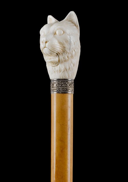 MULTI-FUNCTION WALKING STICK,19th century. Ivory, carved all-around. Large head of a cat with a mechanical muzzle. Malacca wood stick with horn tip. L 97.2 cm.