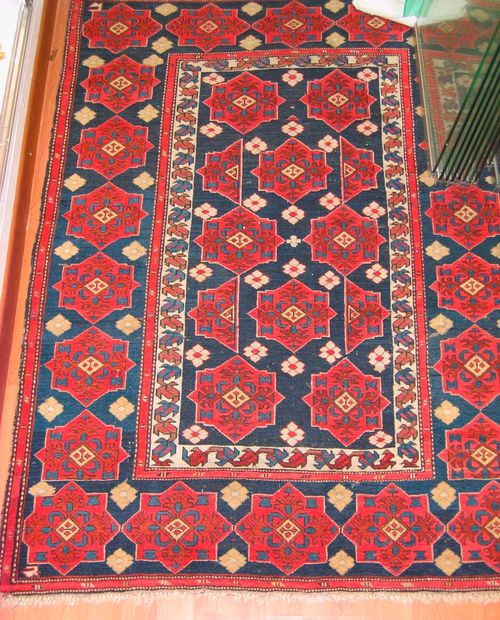 SHIRVAN antique. Central field and border in dark blue, the entire carpet is decorated with pink star-shaped ornaments, signs of wear, 145x105 cm.