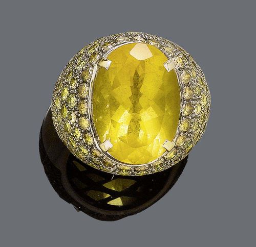 CITRINE AND DIAMOND RING. White gold ca. 700. Large, decorative cocktail model, the convex top set with 1 oval citrine of ca. 20.00 ct and numerous brilliant-cut diamonds, graduated from colourless to brown, weighing ca. 4.00 ct. Size ca. 61.