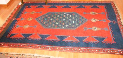 KAZAK old. Red ground with a green medallion, geometrically patterned, blue, red border, slight wear, 205x138 cm.