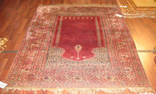 KAYSERI silk, antique.Red mihrab with light green spandrels, wide border in pink and light green with floral decoration, good condition, 190x145 cm. Auction proceeds will be donated to the Basle Zoo.