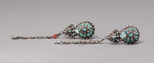 PAIR OF EARRINGS.Tibet, old, L 5.7 cm. Silver set with turquoises. Drop-shaped ornament with three-leaf crown. A double-row silver chain with five flowers for fastening in hair. (2)