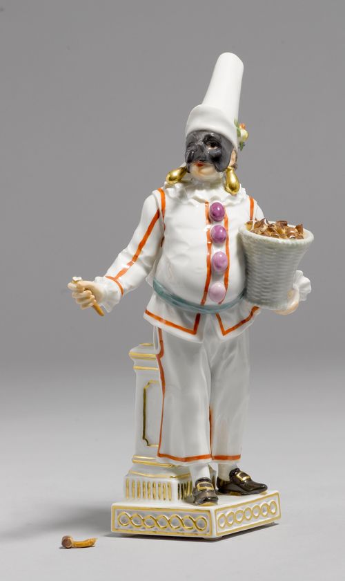 FIGURE OF "PULCINELLO",Meissen, from a series of the Commedia dell'Arte, 20th century. Wearing a black jester's mask, large gold earrings, a white costume with a high hat, and a large hump on his back. Underglaze blue sword mark, model number D. 30 incised, press number. H 20 cm. Slate pencil, broken (piece included).