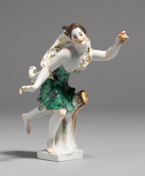 FIGURE OF A NEREID,Meissen, after 1934. Running nereid, lightly dressed with a green cloak and holding an apple in her left hand. On a square base. Underglaze blue sword mark, model number 431 incised, press number. H 19.5 cm. Both hands restored and chipped.