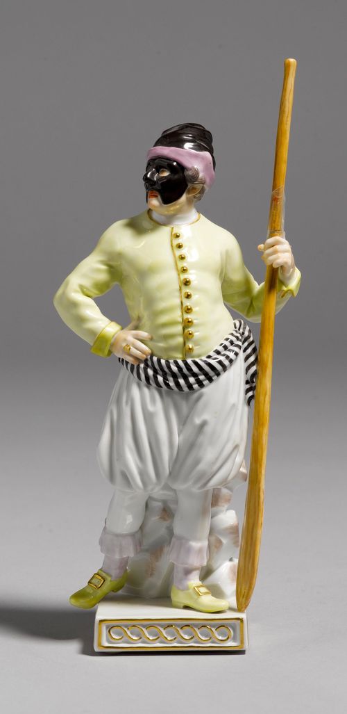 FIGURE OF A "GONDOLIERE" FROM THE COMMEDIA DELL'ARTE,Meissen, modern. Standing on a square base, the face covered with a black mask, wearing a black and purple lined cap, a yellow jacket with gold buttons, and white harem pants with a black, striped belt. Holding his paddle in his left hand. Underglaze blue sword mark, model number 64569 impressed, press number. H 18.5 cm. Paddle broken.