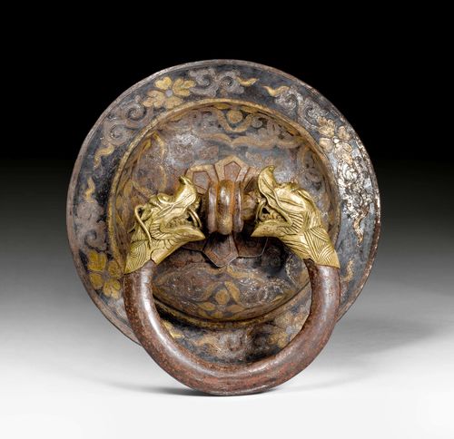 AN IRON DOOR KNOCKER WITH A SILVER AND GOLD DAMASCENE FLORAL PATTERN, THE RING TERMINATING IN DRAGON HEADS. Tibet, 18th/19th c., diameter 24 cm.