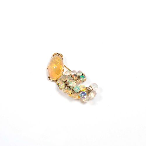 OPAL AND GOLD BROOCH, ca. 1970. Yellow gold. Decorative, asymmetrical brooch set with 1 fine fire opal of ca. 24 x 14.4 x 11.5 mm and additionally decorated with 30 movable opal beads of numerous sizes from 5 to 8.4 mm Ø. Originally also usable as the centre part of a necklace, with removable mechanical part. Cartouche signed Seaman Schepps. Ca. 5.5 x 3 cm.