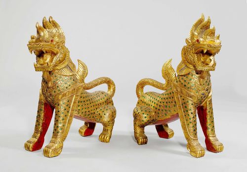 A PAIR OF WOODEN, GOLD-PAINTED TEMPLE LIONS, SET WITH POLYCHROME GLASS TILES. Thailand, height 89 cm. (2)