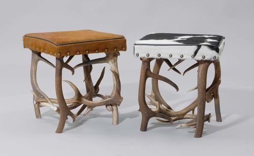2 ANTLER STOOLS, from theAlpine region. Rectangular padded seat covered with grey/white and brown cowhide.