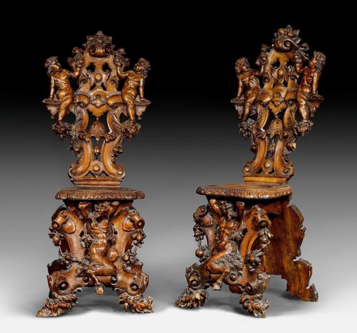 PAIR OF CARVED SGABELLI,in the Renaissance style, Italy, 19th century. Walnut, opulently carved with putti, acanthus leaves, scrolls, fauns, fruit and animal heads. 46x44x123 cm. Some losses, 1 backrest strongly affected by wormholes, 1 break.