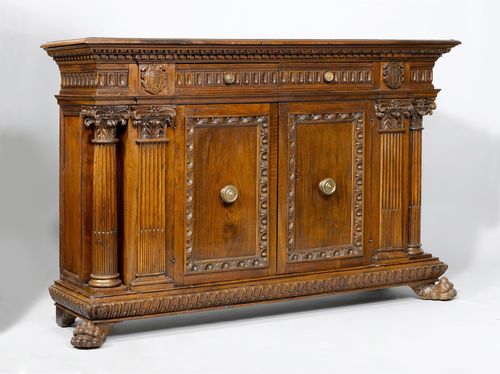 CREDENZA,in the Renaissance style, using old parts, Italy. Walnut, opulently carved with decorative friezes, leaves and coat-of-arms cartouches. Rectangular body, paw feet. Architectural front with 2 drawers and double-doors. Brass handles. 183x53x122 cm. 1 key.