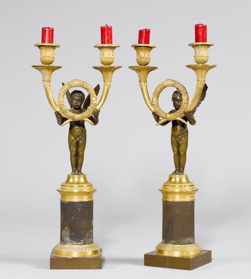 PAIR OF CANDELABRAS GIRANDOLEN &quot;A L&#39;ANGELOT&quot;,Empire, Paris, ca. 1810/15. Matte and polished gilt bronze, and burnished bronze. Cupid standing on a half-sphere, bearing a laurel wreath with 2 curved light branches with broad drip pans and vase-shaped nozzles. H 41.5 cm.