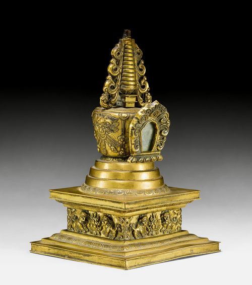 A SMALL GILT COPPER ALLOY STUPA DECORATED WITH SNOW LIONS AND MAKARA MASKS. China/Mongolia, 19th c. Height 16 cm. Tip is missing.