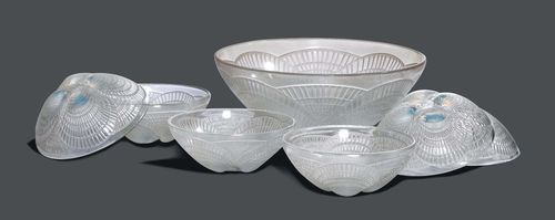 RENE LALIQUE SMALL SERVICE "COQUILLES", circa 1940 White, opalescent pressed glass. Comprising: 6 small bowls and a large bowl. Decorated with shells. Signed R. Lalique France. D 13 cm and 24 cm.