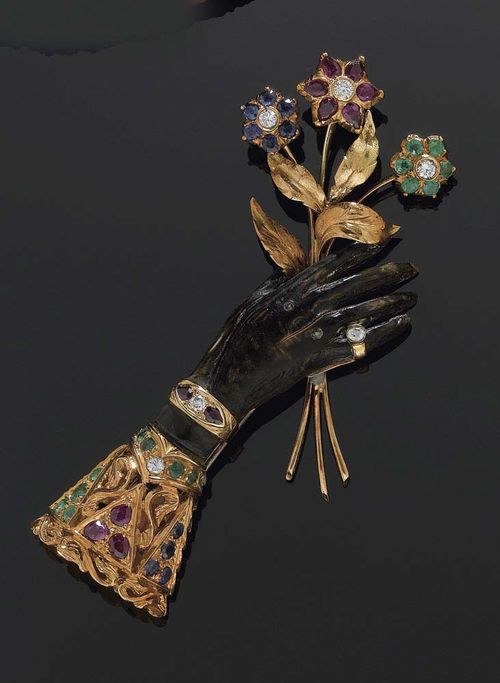 PRECIOUS STONE AND DIAMOND CLIP BROOCH, S. NARDI, circa 1940. Red gold. Hand-shaped brooch, set with 11 rubies, 10 sapphires, 14 emeralds totalling ca. 3-00 ct and 6 diamonds totalling ca. 0.30 ct.