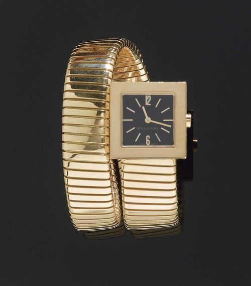 LADY'S WRISTWATCH, BULGARI QUADRATO, circa 1990. Yellow gold 750. Square case No. F472 with  polished bezel and black dial, gold coloured indices and hands. Ref. SQ221TY, Quartz movement. Tubogas-strap. Barely worn, with original case.