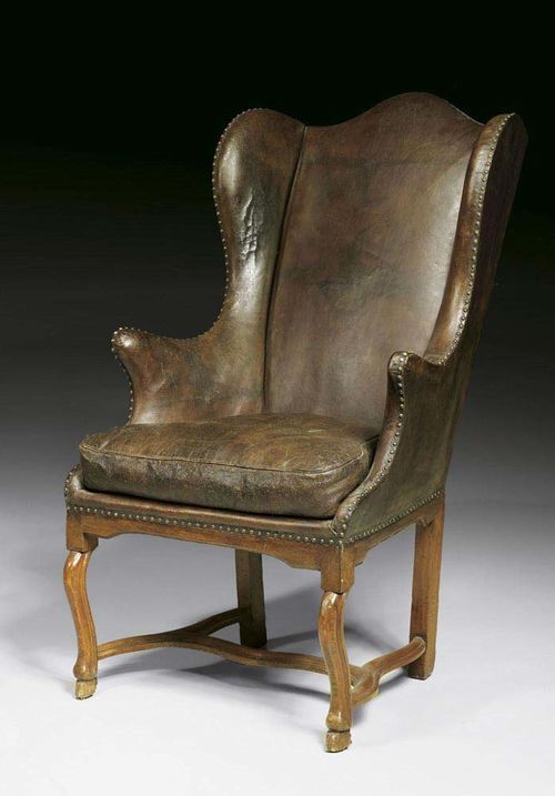 WING BACK CHAIR, Louis XV, German, 18th century Moulded walnut, fully upholstered with brown leather covers and decorative nailwork, with cushion. 71x50x55x124 cm. Provenance: Private collection, Munich