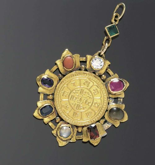 GOLD AND GEMSTONE COIN PENDANT WITH CHAIN, Nepal ca. 1925. Yellow gold Exceptional pendant with 1 gold Tola (Ashraphi) in the center, dated VS 1979 = 1922 AD, surrounded by radially organized, stylized lotus blossoms, each of them decorated with a jewel, e.g. a precious stone: 1 old-mine-cut diamond of ca. 1.00 ct, ca. H-I/SI2, 1 antique oval ruby of ca. 1.70 ct, 1 oval agate cabochon, 1 antique oval Hessonite of ca. 1.00 ct, 1 half cultured pearl, 1 antique oval sapphire of ca. 1.20 ct, 1 oval amethyst of ca. 0.60 ct, 1 oval coral cabochon. The attache is adorned with an emerald carré of ca. 0.50 ct. Shows some signs of wear and repair. With solid gold chain L ca. 46.5 cm.