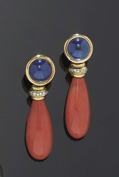 CORAL, SAPPHIRE AND DIAMOND PENDANT EARRINGS. Yellow gold 750. Casual elegant stud earrings consisting of 2 long coral drops, each mounted on a diamond-set ring totaling ca.0.20 ct on a movable mount below 2 round sapphire cabochons totaling ca. 8.50 ct.