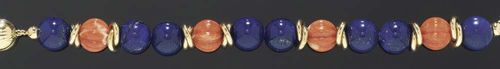 LAPIS-LAZULI, CORAL AND GOLD BRACELET. Yellow gold 750. Decorative bracelet consisting of 8 lapis-lazuli beads with a diameter of ca. 12 mm, alternately strung with 4 grooved coral beads, flanked by pairs of interlaced gold rings. L 19 cm.