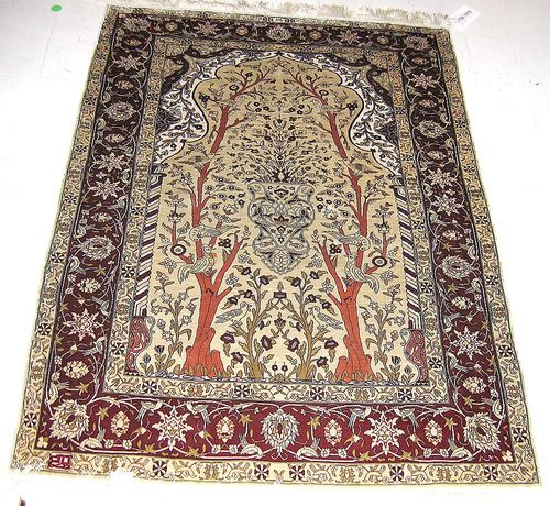 SILK HEREKE, signed. Beige mihrab with two trees of life, birds and plants. With red border. Slightly stained, otherwise good condition. 140x100 cm.