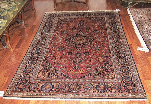 KESHAN old. Old rose round with blue central medallion finely patterned with trailing flowers and palmettes in harmonious colours. Blue border. Good condition. 200x131 cm.
