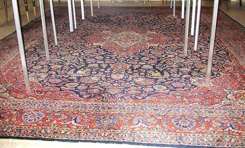 KESHAN old. Blue central field with red/white central medallion and corner motifs. Lavishly decorated with trailing flowers and palmettes in harmonious colours. Red border. Good condition. 413x320 cm.