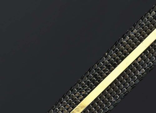 GOLD AND STEEL BRACELET, DONNA GIOIELLI, Florence ca 1990. Yellow gold 750 and steel. Decorative, broad blackened steel scale-braided bracelet, mid-line decorated with a flat gold band. Gold fastener. L ca. 19 cm. W 3 cm.