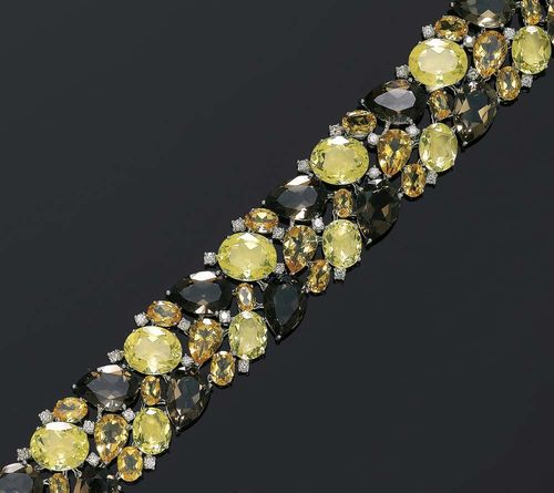 CITRINE, PRASIOLITE, SMOKY QUARTZ AND BRILLANT-SET DIAMOND BRACELET. White gold 750. Modern elegant bracelet, completely set with 48 differently shaped gemstones, citrine, prasiolite and smoky quartz totalling ca. 110.00 ct, the intermediary spaces are set with 35 brilliant-cut diamonds totalling ca. 2.00 ct. L 17 cm. Matches the following lots.