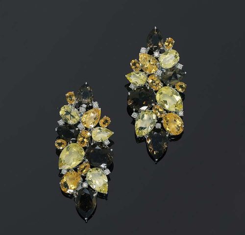 CITRINE, PRASIOLITE, SMOKY QUARTZ AND BRILLIANT-CUT DIAMOND CLIP EARRINGS. White gold 750. Modern elegant, navette-shaped clips/stud earrings set with 30 differently shaped gemstones, citrine, prasiolite and smoky quartz totalling ca. 54.00 ct, in between each stone are 8 brilliant-cut diamonds totalling. ca. 0.80 ct. Matches the following lot.